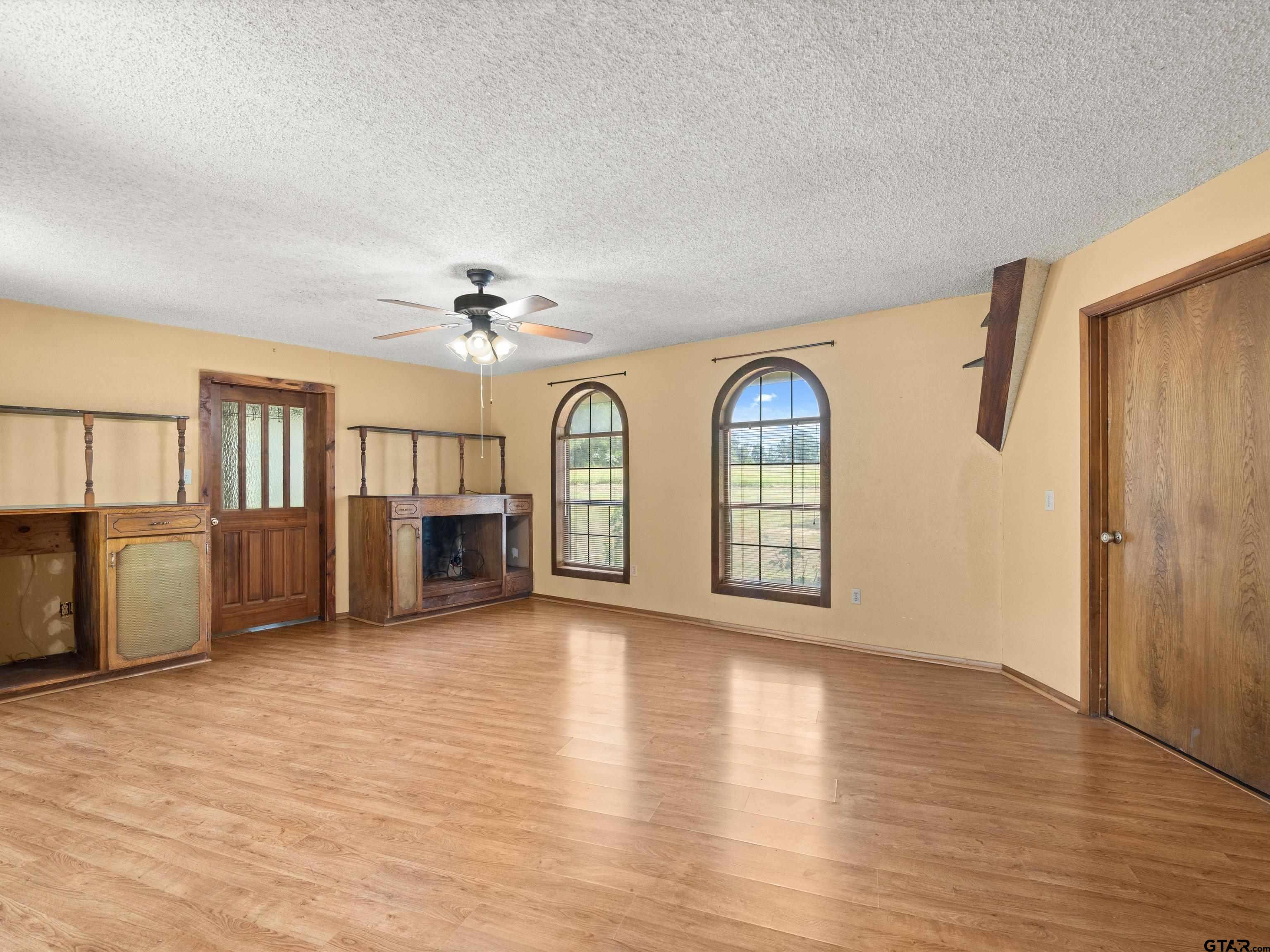 637 County Road 3201 Daingerfield, TX 75638 - Photo 17 of 33 an empty room with wooden floor fireplace and windows