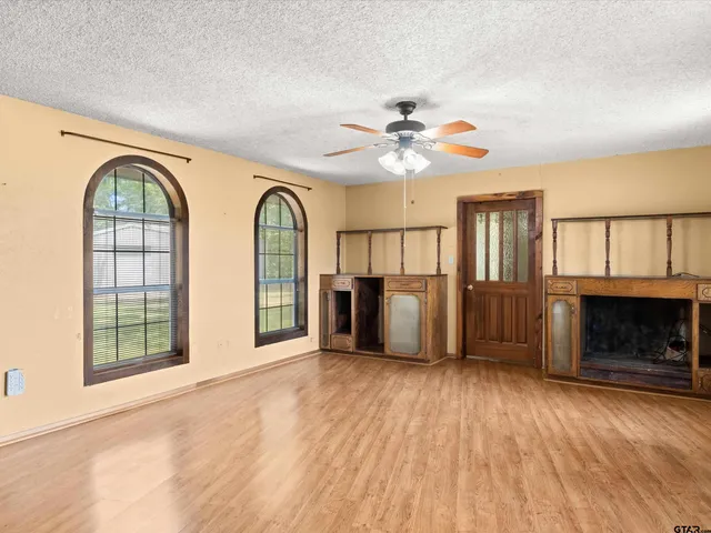 an empty room with a ceiling fan and a window