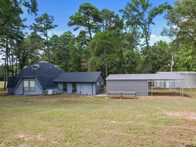a view of a house with pool and a yard