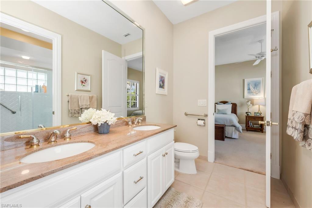 10200 Idle Pine Lane Estero, FL 34135 - Photo 15 of 19 a en suite bathroom with a granite countertop double vanity sink a mirror and a toilet