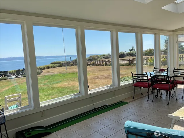 a living room with furniture and floor to ceiling windows