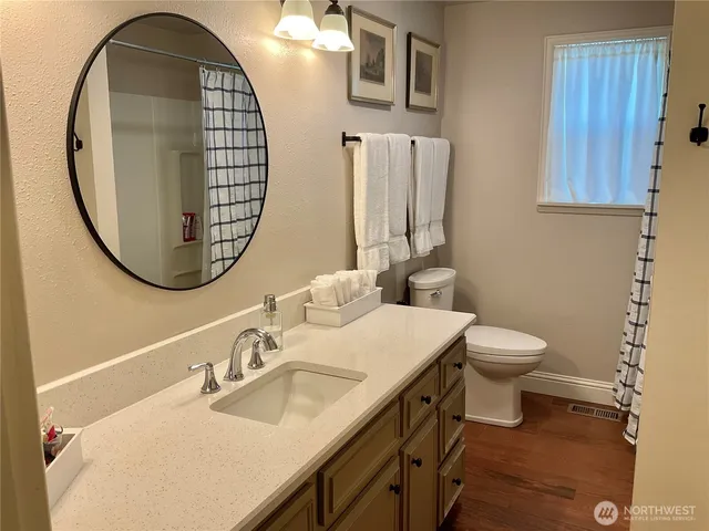 a bathroom with a toilet a sink and a mirror