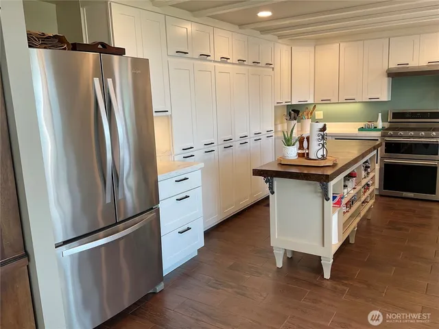 a kitchen with stainless steel appliances granite countertop a refrigerator a stove a sink and a refrigerator