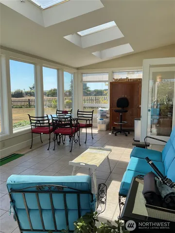 a living room with furniture a large window and a dining table