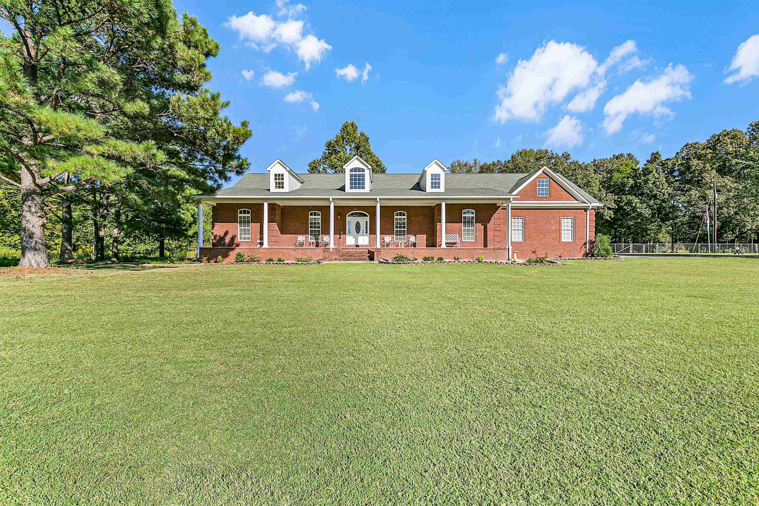 400 Hughes Road East Jackson, TN 38305 - Photo 1 of 36 a front view of a house with a garden and trees