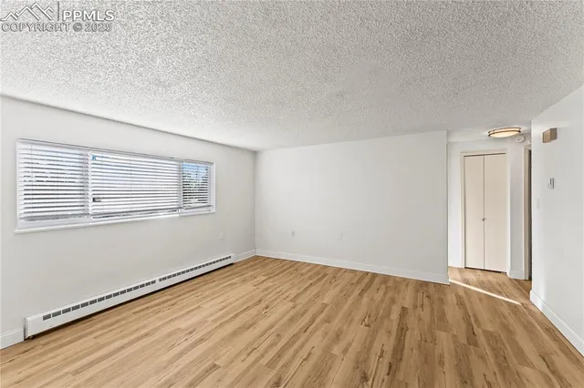 a view of a kitchen with wooden floor and a refrigerator