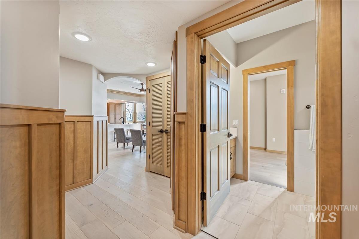 79 East Aikens Road, Unit 202 Eagle, ID 83616 - Photo 4 of 47 Hallway featuring arched walkways, wainscoting, recessed lighting, and light wood finished floors