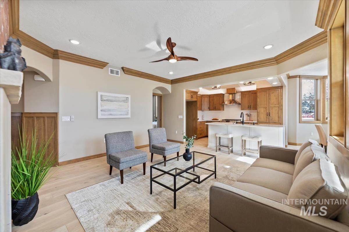 79 East Aikens Road, Unit 202 Eagle, ID 83616 - Photo 7 of 47 Living room with arched walkways, light wood-style floors, ceiling fan, crown molding, and recessed lighting