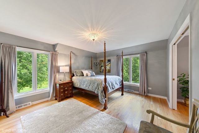 a bed sitting in a spacious bedroom next to a window