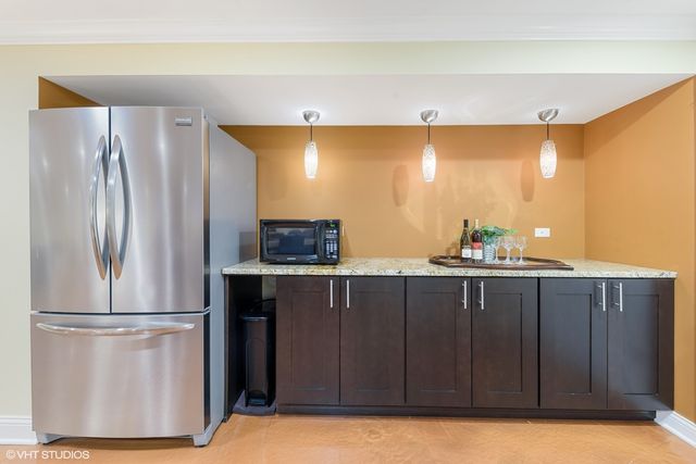 a kitchen with stainless steel appliances a refrigerator and a wooden cabinets