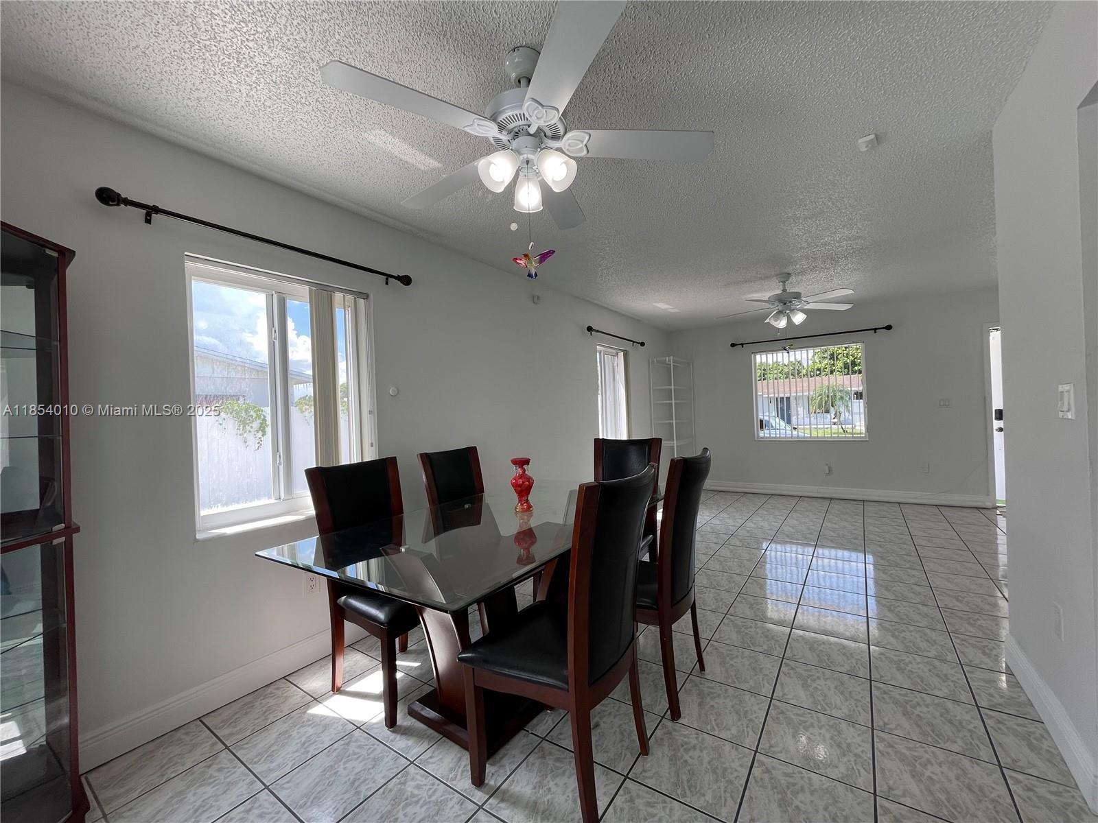 15550 Southwest 308th Street, Unit 15550 Homestead, FL 33033 - Photo 3 of 11 a view of a dining room with furniture and chandelier