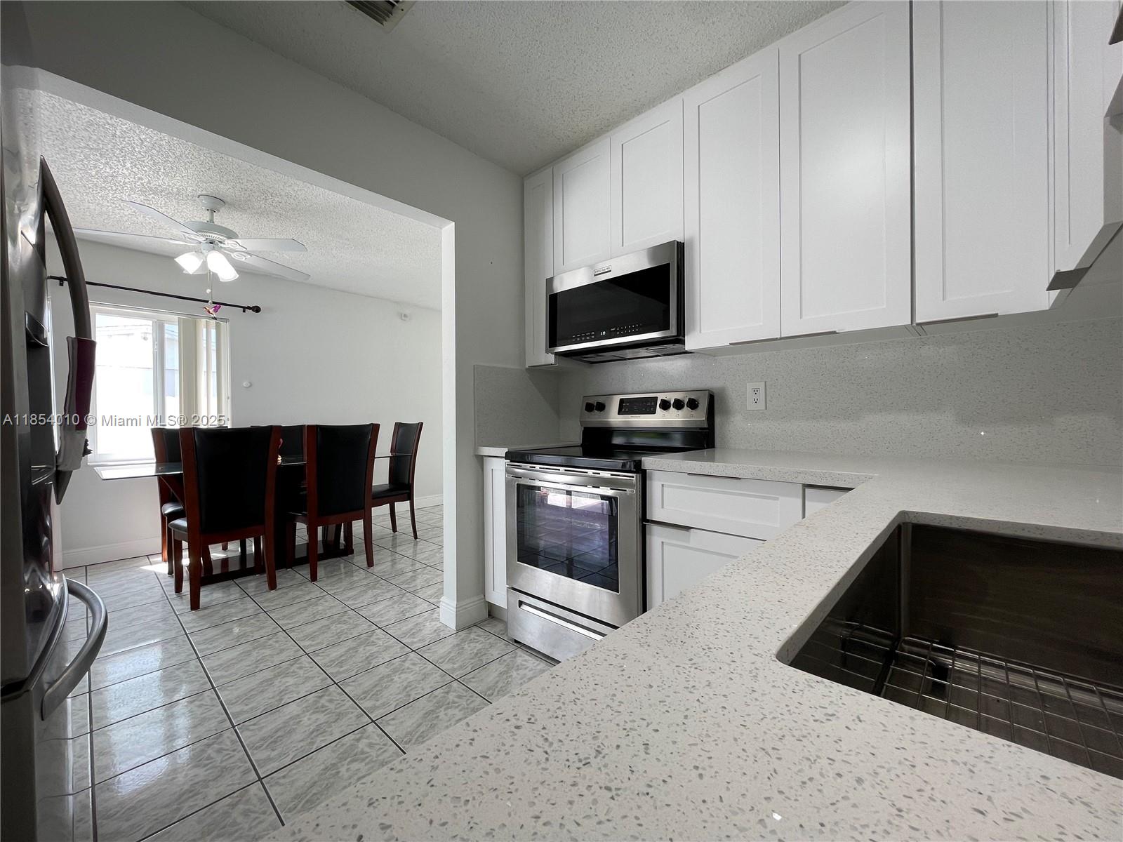 15550 Southwest 308th Street, Unit 15550 Homestead, FL 33033 - Photo 4 of 11 a kitchen with stainless steel appliances a stove a sink and a microwave
