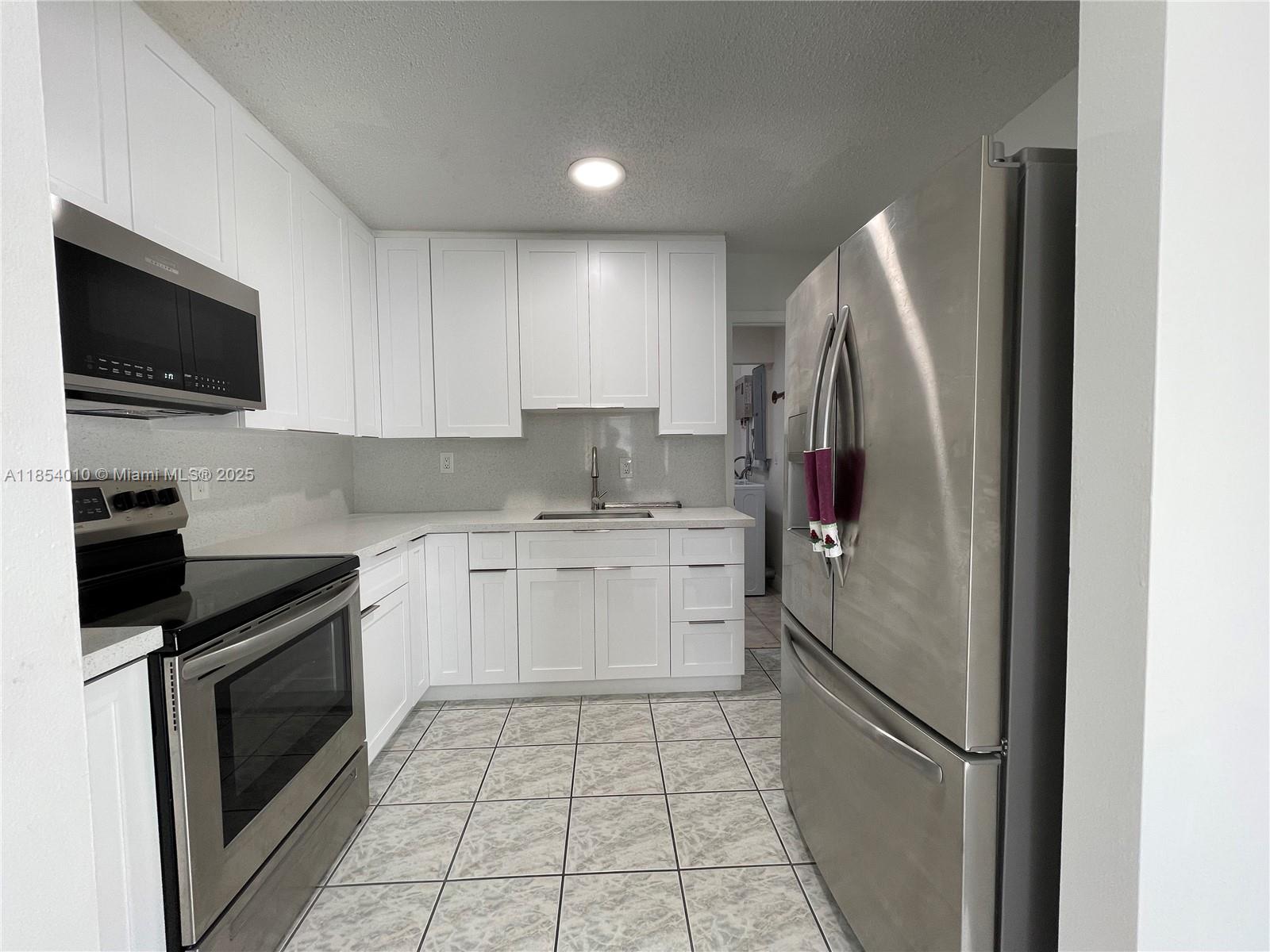 15550 Southwest 308th Street, Unit 15550 Homestead, FL 33033 - Photo 5 of 11 a kitchen with a sink stove and refrigerator