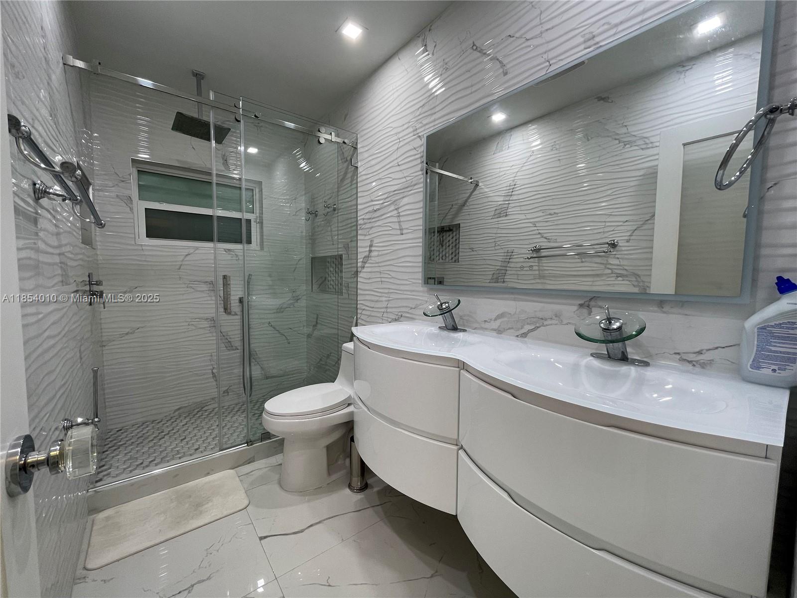 15550 Southwest 308th Street, Unit 15550 Homestead, FL 33033 - Photo 6 of 11 a bathroom with a double vanity sink toilet and shower