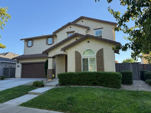 a front view of a house with a yard and garage