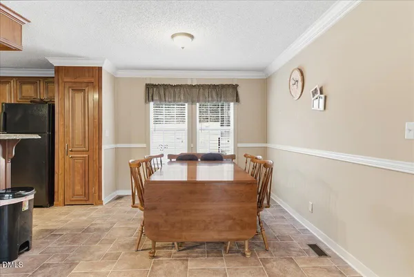 a kitchen with stainless steel appliances a dining table chairs a sink and dishwasher