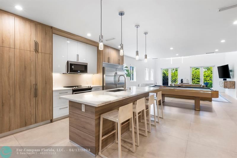 a kitchen with kitchen island stainless steel appliances a table and chairs