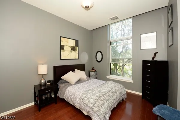 a bedroom with a bed and a dresser next to a window