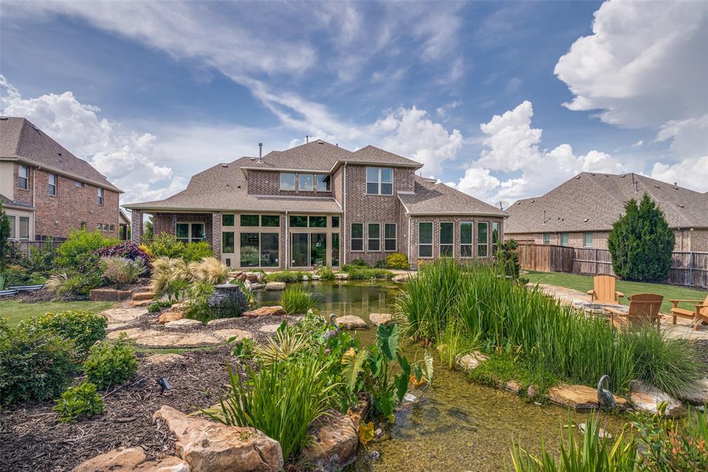 388 Bethany Road Sunnyvale, TX 75182 - Photo 35 of 40 Rear exterior featuring a large koi swimming pond with natural rock accents, extensive landscaping, and an enclosed patio area