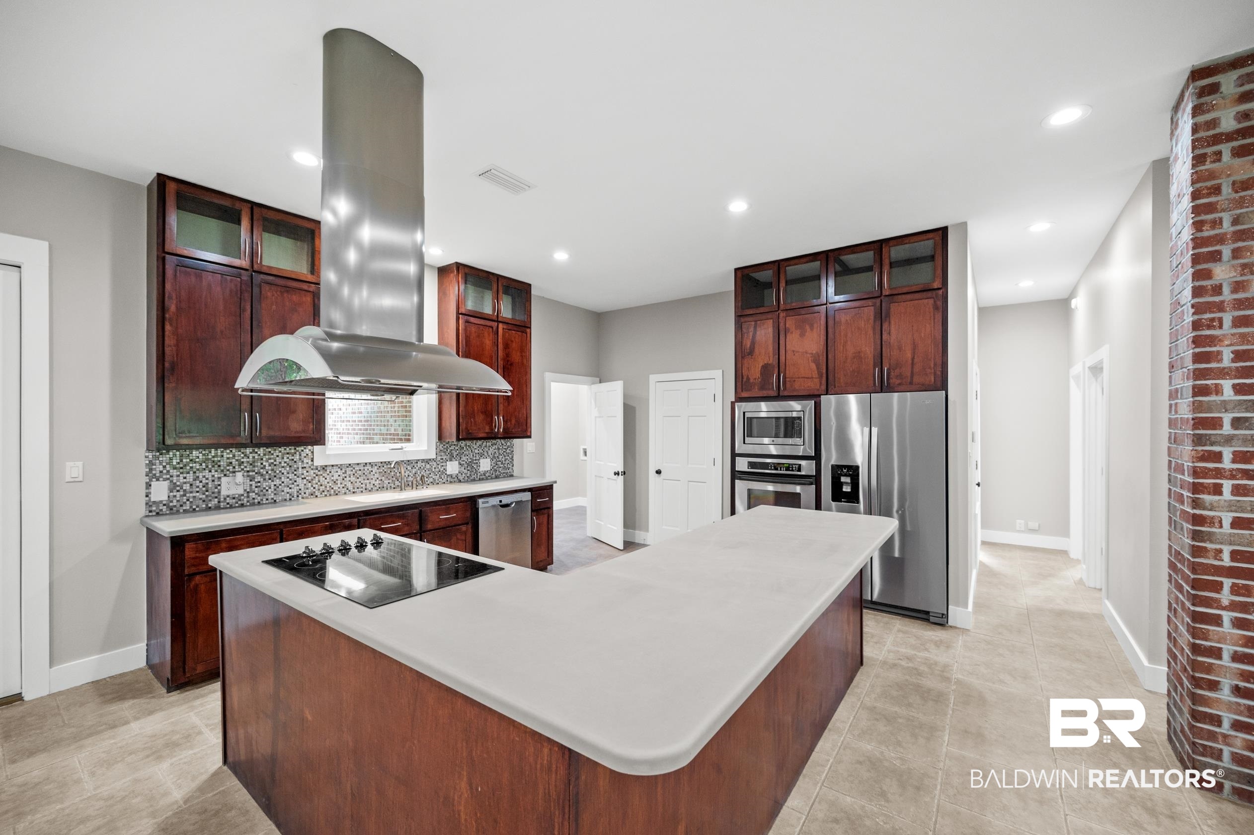 15031 Timber Ridge Drive Loxley, AL 36551 - Photo 12 of 43 Kitchen with light tile patterned flooring, island exhaust hood, a center island, appliances with stainless steel finishes, and backsplash