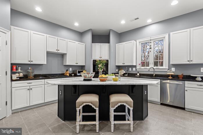 2520 Stone Cliff Drive Baltimore, MD 21209 - Photo 23 of 72 a kitchen with stainless steel appliances granite countertop a stove a sink dishwasher and white cabinets with wooden floor