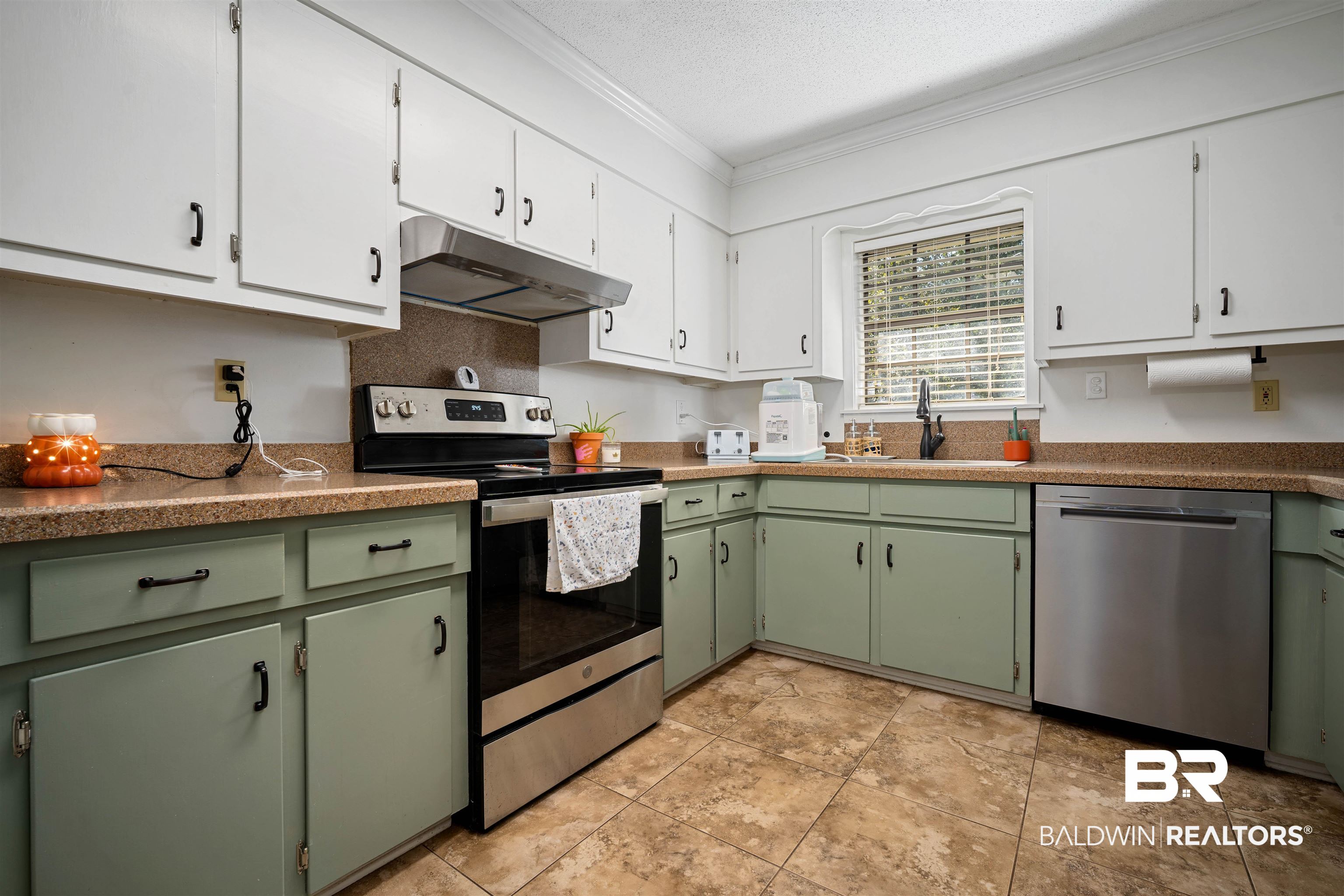 74 Caisson Trace Spanish Fort, AL 36527 - Photo 7 of 26 Kitchen featuring green cabinets, white cabinetry, appliances with stainless steel finishes, under cabinet range hood, and crown molding