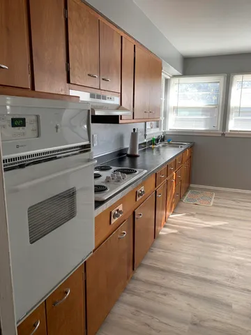 a kitchen with stainless steel appliances granite countertop a stove a sink and a microwave