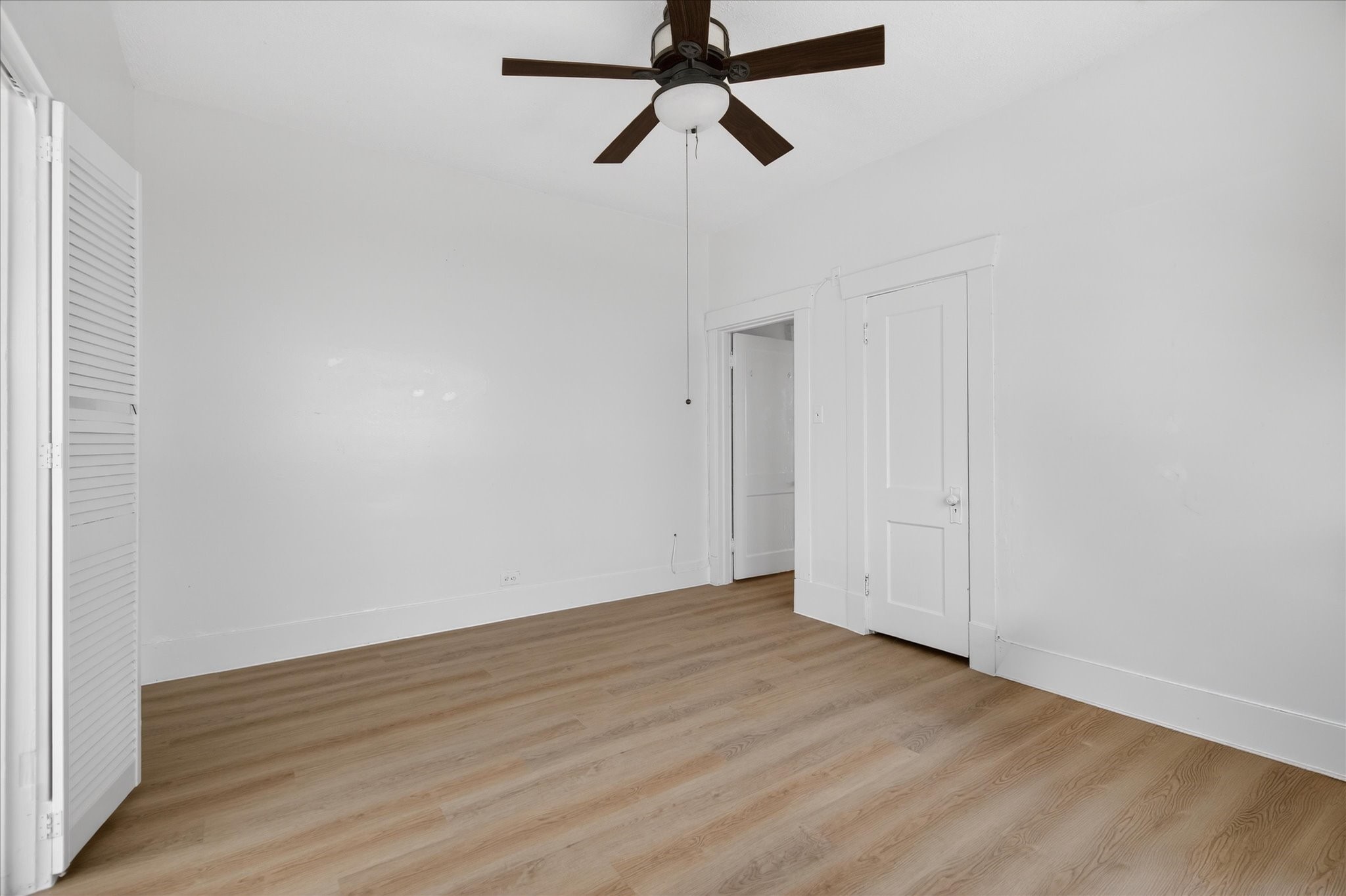 1607 Holman Street Houston, TX 77004 - Photo 17 of 24 a view of a room with wooden floor and ceiling fan