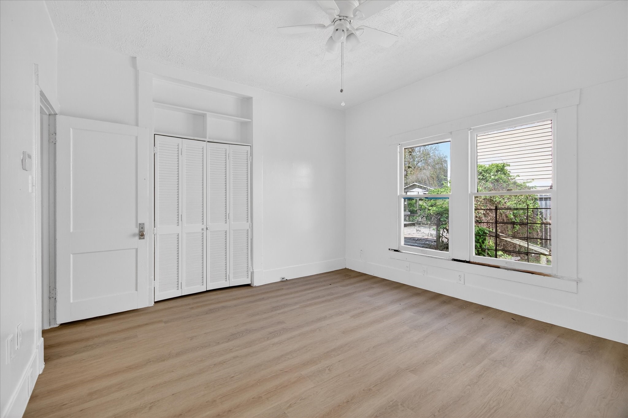1607 Holman Street Houston, TX 77004 - Photo 19 of 24 a view of an empty room with wooden floor and a window