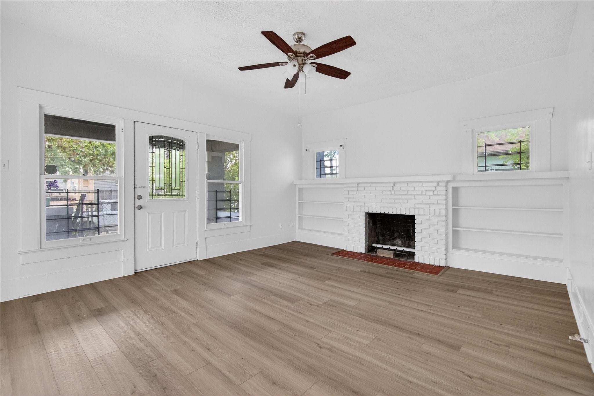 1607 Holman Street Houston, TX 77004 - Photo 4 of 24 a view of an empty room with wooden floor and a fireplace