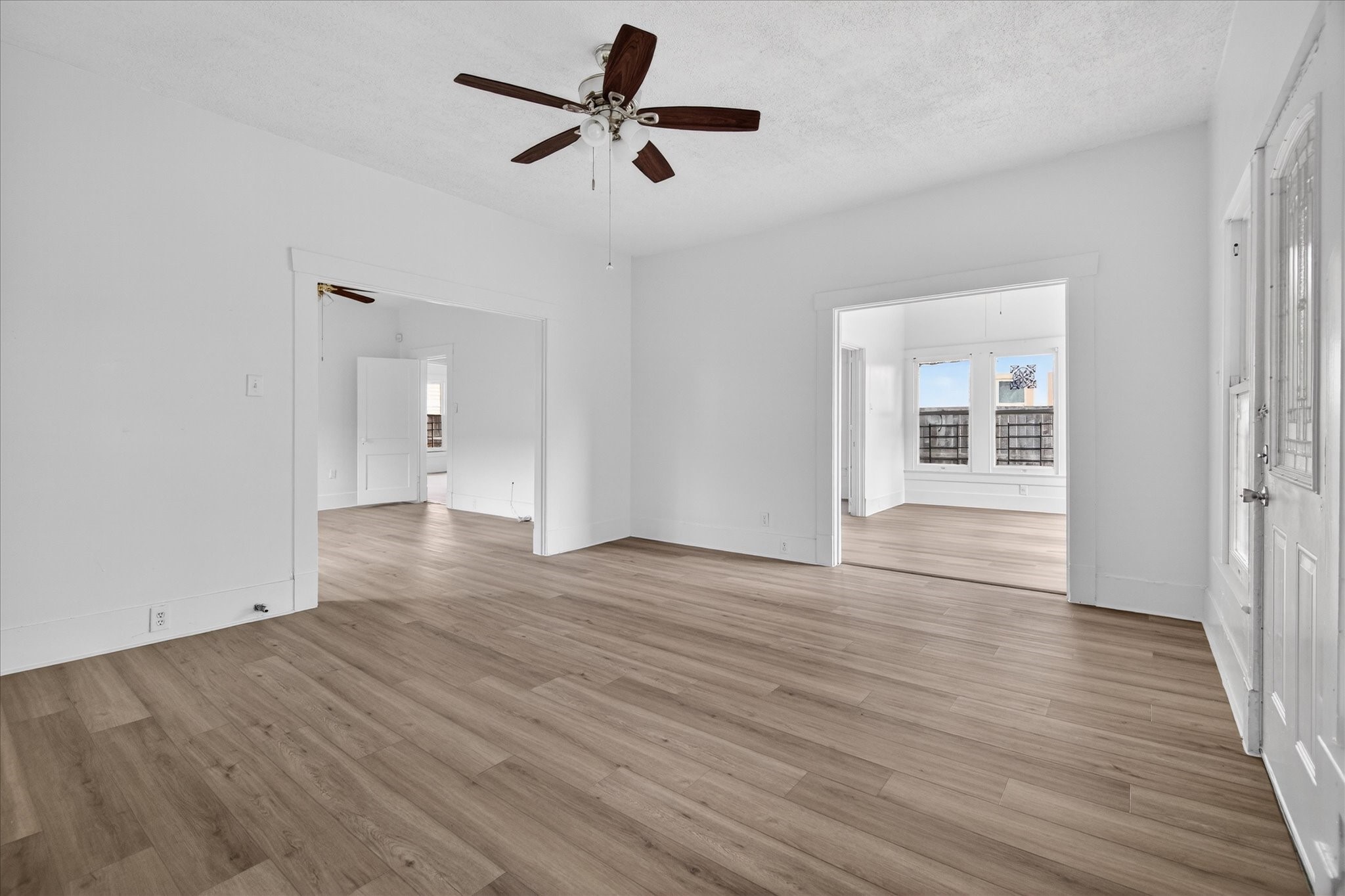1607 Holman Street Houston, TX 77004 - Photo 6 of 24 a view of empty room with wooden floor and ceiling fan