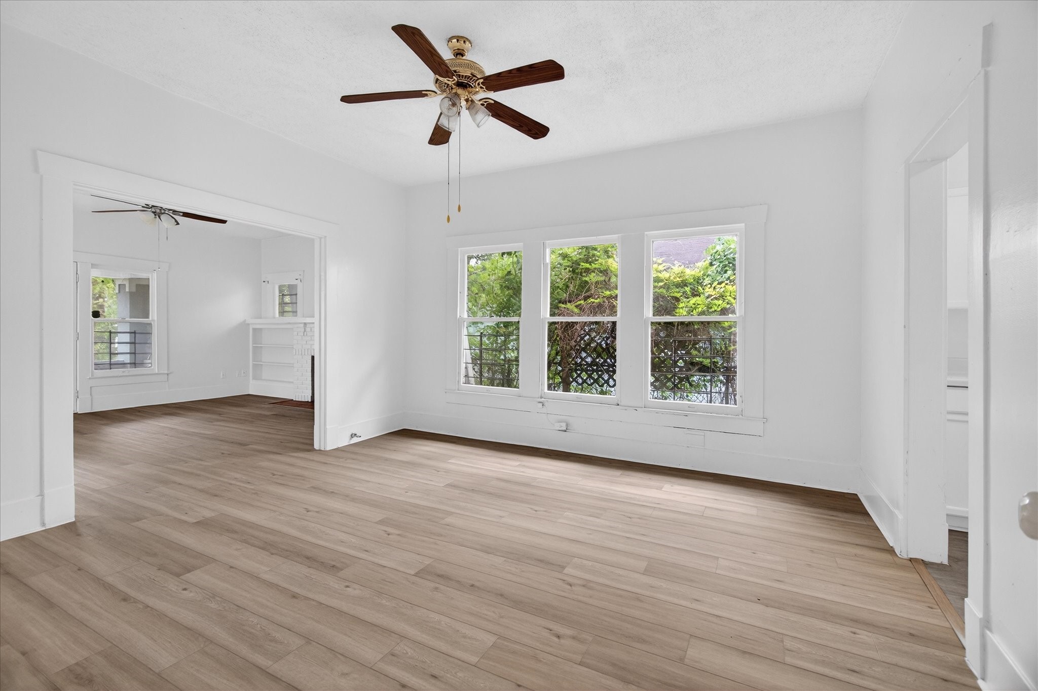1607 Holman Street Houston, TX 77004 - Photo 8 of 24 a view of an empty room with wooden floor and a window