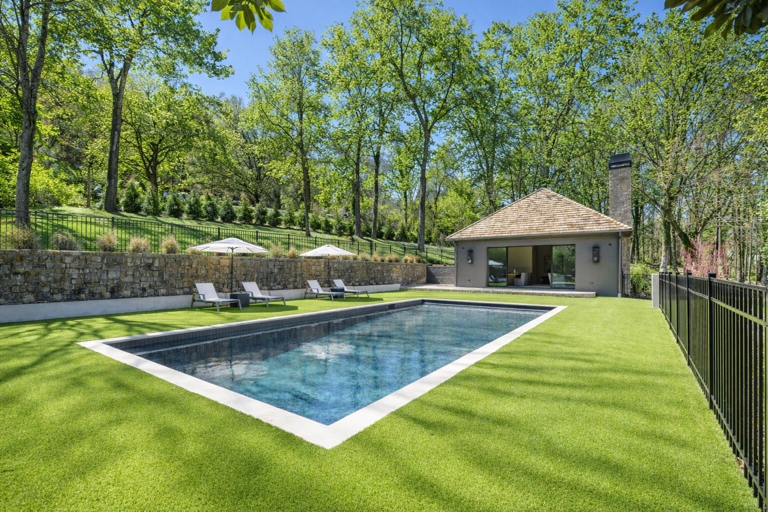 1049 Overton Lea Road Nashville, TN 37220 - Photo 43 of 53 a view of a swimming pool with a table and chairs under an umbrella