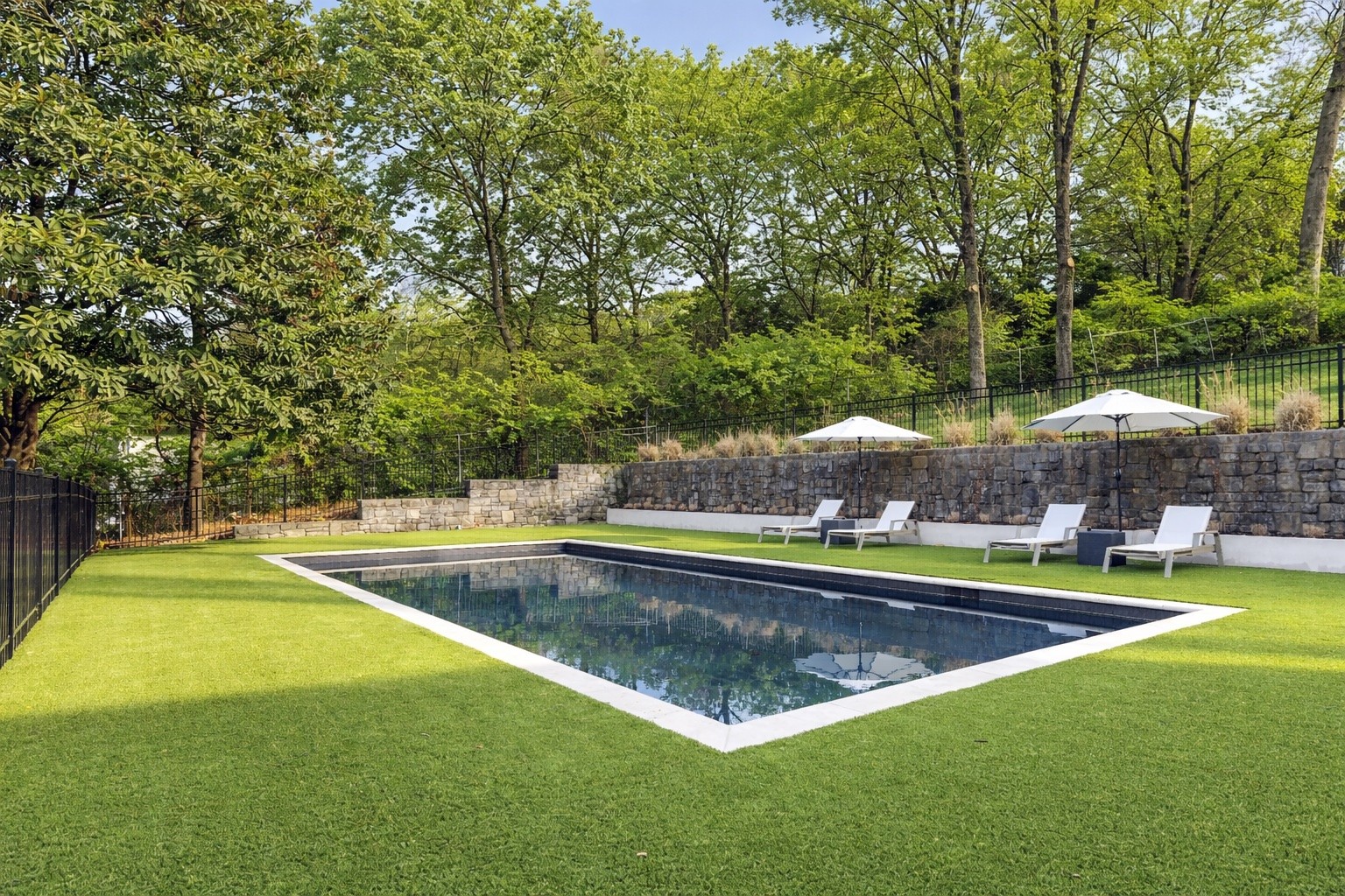 1049 Overton Lea Road Nashville, TN 37220 - Photo 44 of 53 a view of a swimming pool with lawn chairs under an umbrella