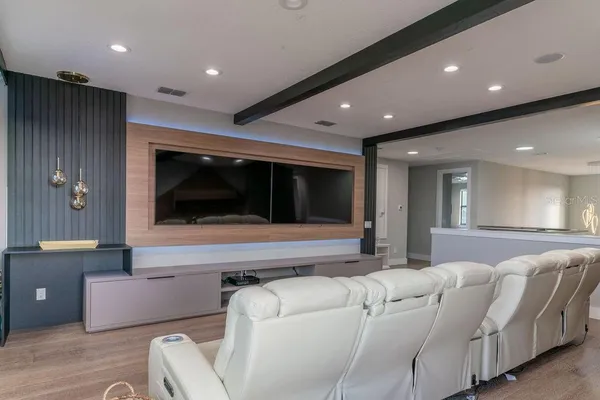 a bedroom with a bed and dresser with wooden floor