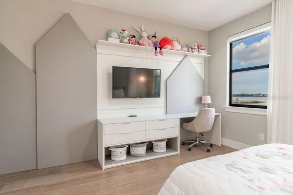 a bedroom with a bed and a window with chair