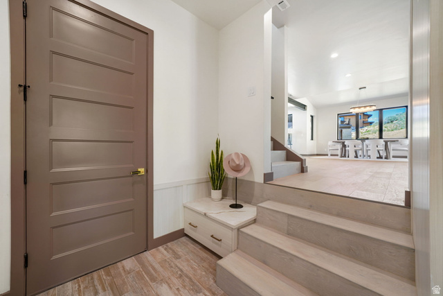 10646 North Reflection Ridge Hideout, UT 84036 - Photo 5 of 43 Entryway featuring wood-finish flooring, white wainscoting, and a multi-panel door with brass hardware