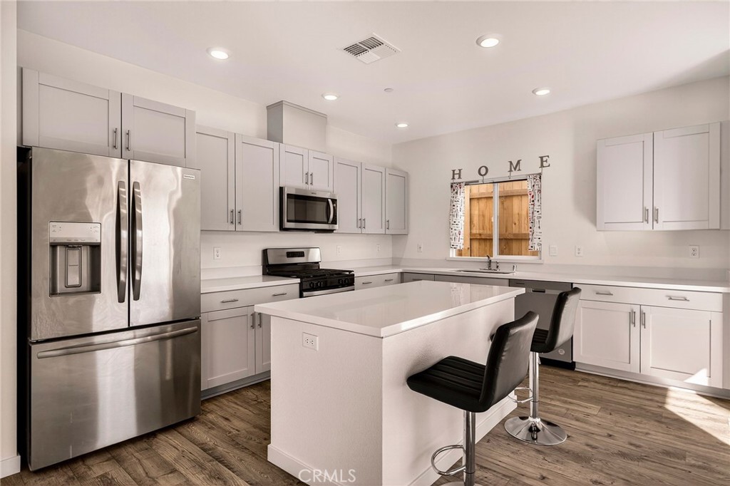 1147 Lentil Way Chico, CA 95928 - Photo 25 of 72 a kitchen with a sink a refrigerator a microwave and cabinets