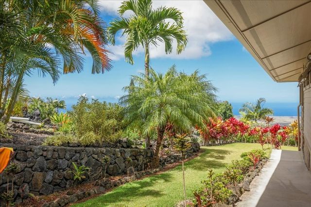 a bunch of flowers in front of yellow house