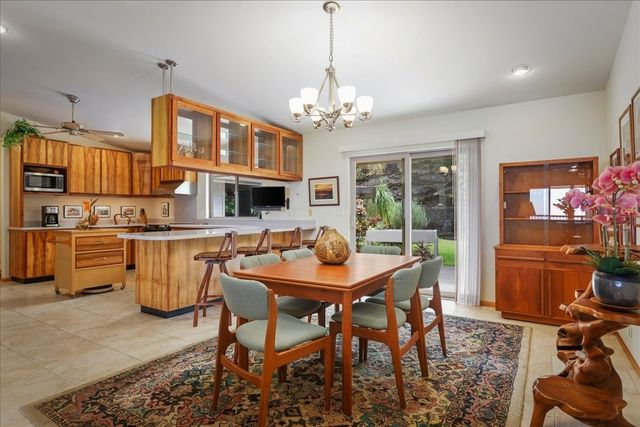a dining room with furniture a chandelier and kitchen view