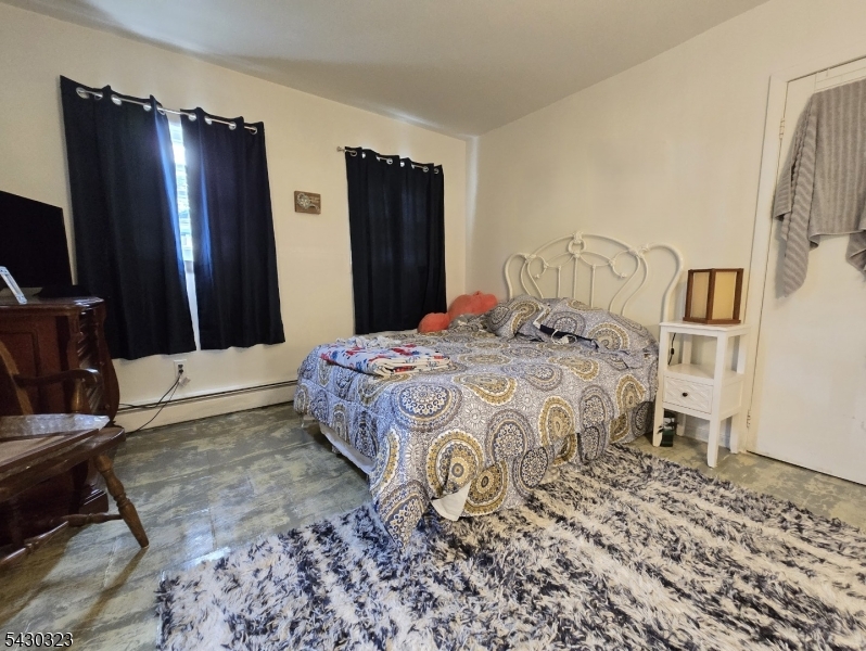 83 Allen Street, Unit 1 Netcong, NJ 07857 - Photo 11 of 16 a bedroom with a bed dresser and a flat tv screen