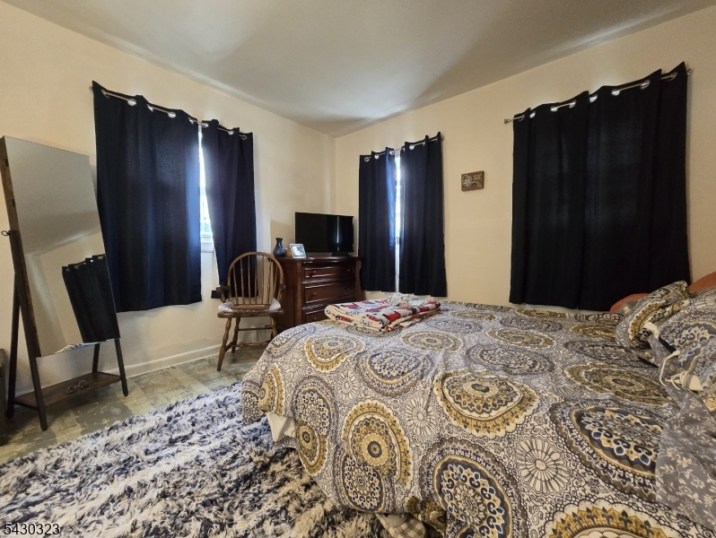 83 Allen Street, Unit 1 Netcong, NJ 07857 - Photo 12 of 16 a bedroom with a bed dresser and a large mirror
