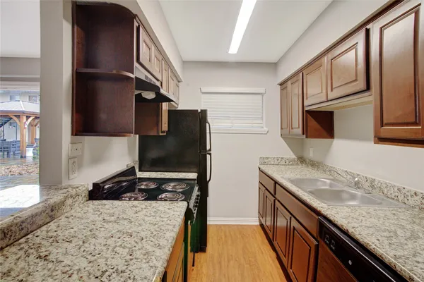 a kitchen with stainless steel appliances granite countertop a sink stove microwave and refrigerator