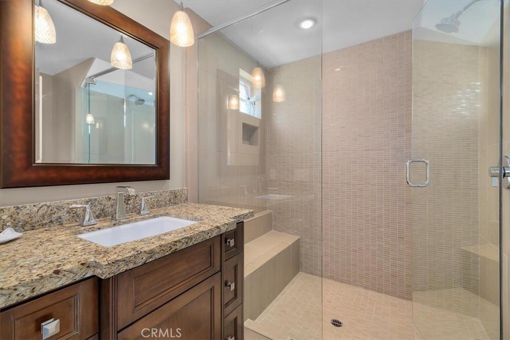 133 Upper Terrace Road Avalon, CA 90704 - Photo 32 of 72 a bathroom with a granite countertop sink a mirror and a shower