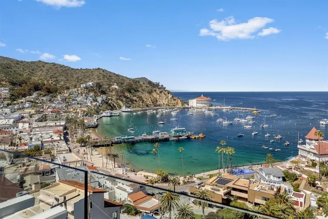 a view of a white building among the street with palm trees