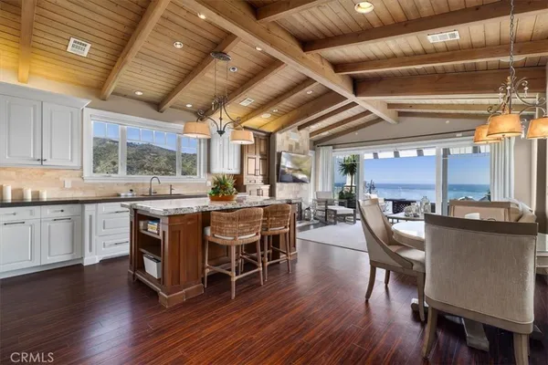 a kitchen with a table chairs white cabinets and wooden floor