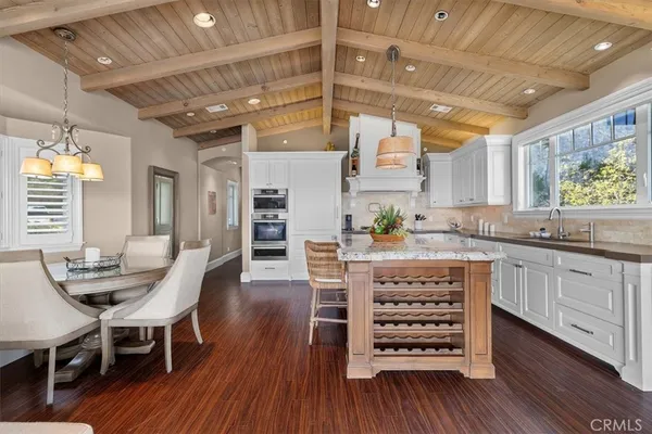 a kitchen with stainless steel appliances granite countertop a sink a stove and a wooden floors