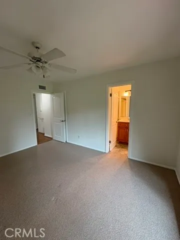 an empty room with a chandelier fan and windows