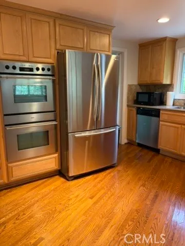 a kitchen with granite countertop a refrigerator and a stove top oven