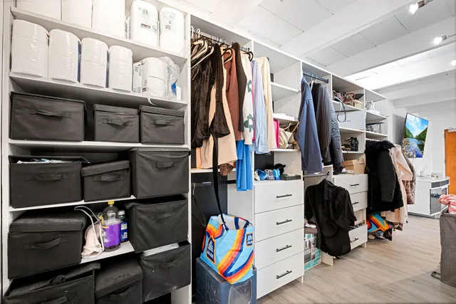 a view of walk in closet with clothes and shoes